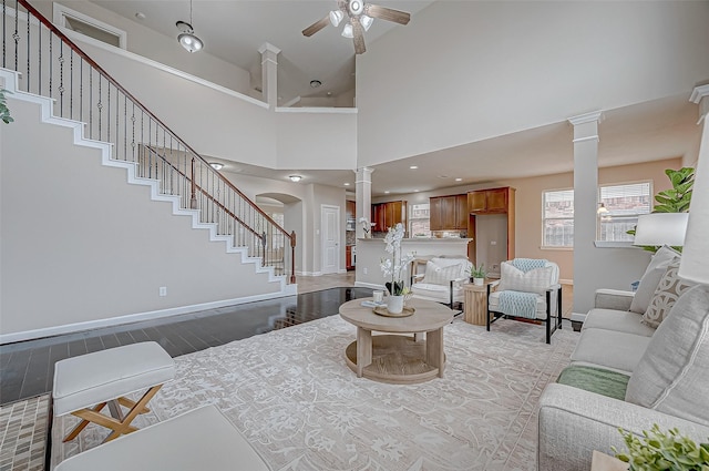 8231 Groveland Hills Dr, Cypress, TX 77433 - living area featuring ornate columns, light wood finished floors, a ceiling fan, stairway, and baseboards