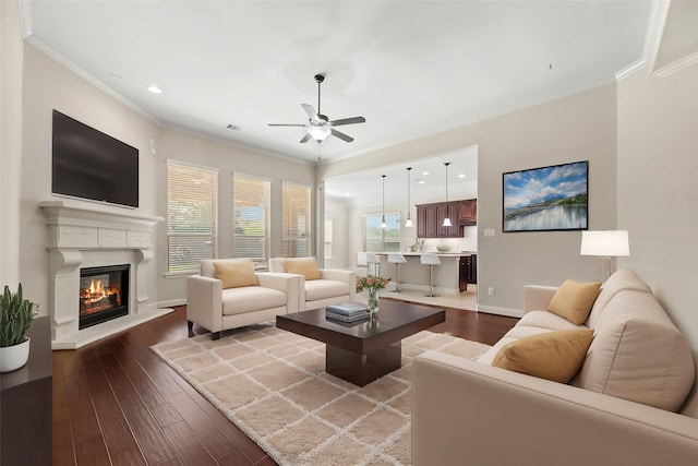 6015 Verde Place Ln, Katy, TX 77493 - living area with a ceiling fan, dark wood-style flooring, recessed lighting, a glass covered fireplace, and crown molding