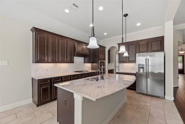 6015 Verde Place Ln, Katy, TX 77493 - kitchen featuring stainless steel appliances, arched walkways, a sink, ornamental molding, and dark brown cabinetry