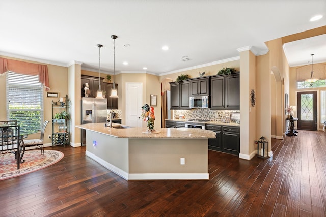 24119 Blue Crest Dr, Porter, TX 77365 - kitchen featuring arched walkways, appliances with stainless steel finishes, an island with sink, tasteful backsplash, and recessed lighting