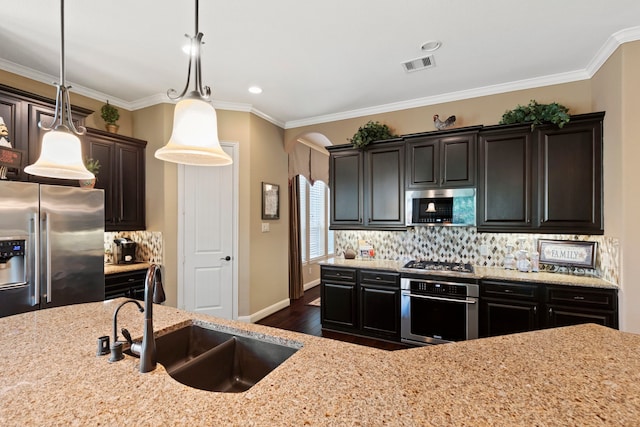 24119 Blue Crest Dr, Porter, TX 77365 - kitchen with stainless steel appliances, a sink, arched walkways, dark wood finished floors, and light stone countertops