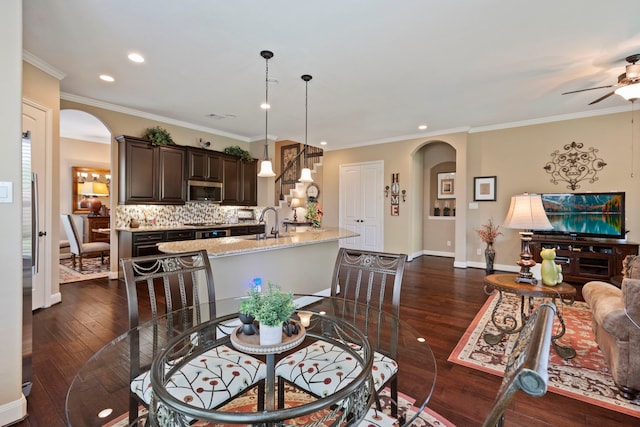 24119 Blue Crest Dr, Porter, TX 77365 - dining area featuring arched walkways, dark wood finished floors, a ceiling fan, recessed lighting, and crown molding