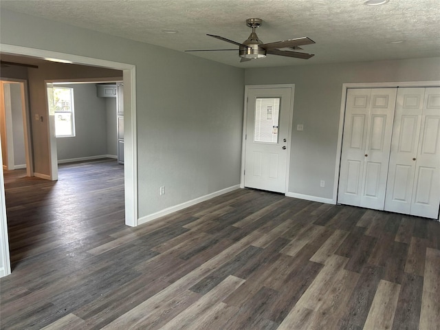 6698 Verde St, Groves, TX 77619 - unfurnished living room featuring ceiling fan, baseboards, dark wood-style floors, and a textured ceiling