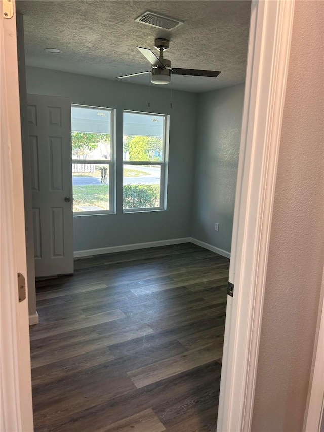 6698 Verde St, Groves, TX 77619 - unfurnished room with a textured ceiling, ceiling fan, dark wood-style flooring, and baseboards