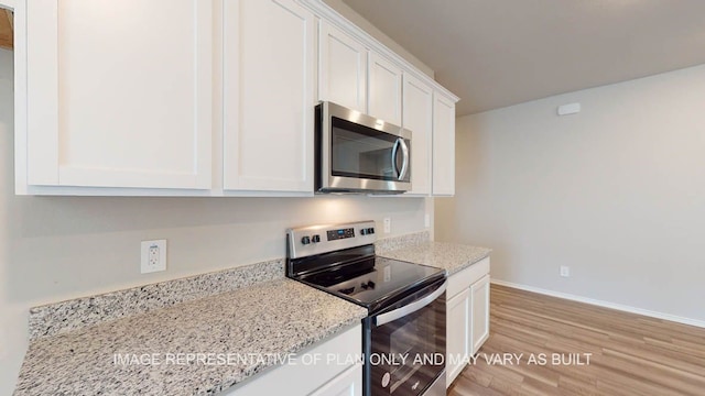 12512 Tarres Ct, Lorena, TX 76655 - kitchen with stainless steel appliances, white cabinets, light wood-type flooring, baseboards, and light stone counters
