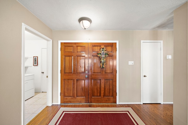 907 S Peach Hollow Ct, Pearland, TX 77584 - foyer featuring wood finished floors, washer / dryer, baseboards, and a textured ceiling