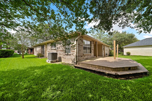 907 S Peach Hollow Ct, Pearland, TX 77584 - back of house with central AC, a deck, a lawn, and brick siding