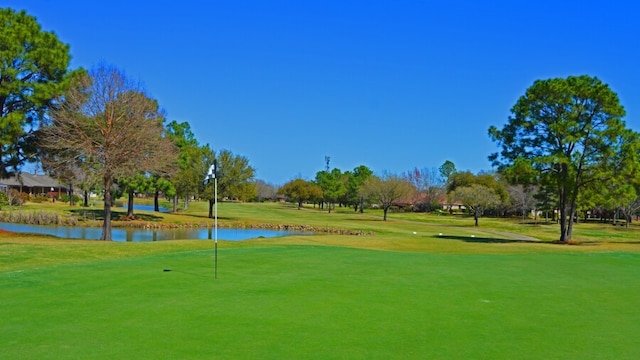 907 S Peach Hollow Ct, Pearland, TX 77584 - view of community with a water view, a yard, view of golf course, and an area to practice putting