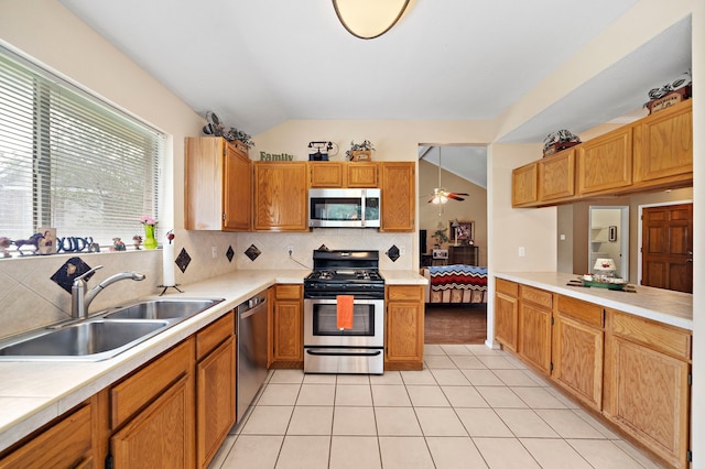 907 S Peach Hollow Ct, Pearland, TX 77584 - kitchen featuring stainless steel appliances, a sink, tasteful backsplash, lofted ceiling, and light countertops