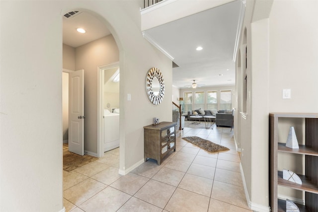 20511 Noble Ranch Ct, Richmond, TX 77407 - hallway featuring arched walkways, light tile patterned floors, separate washer and dryer, baseboards, and recessed lighting