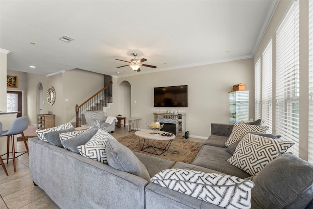 20511 Noble Ranch Ct, Richmond, TX 77407 - living room with arched walkways, stairway, a ceiling fan, crown molding, and a fireplace