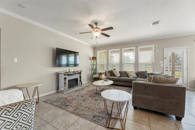 20511 Noble Ranch Ct, Richmond, TX 77407 - living room with ceiling fan, light tile patterned flooring, ornamental molding, a stone fireplace, and baseboards