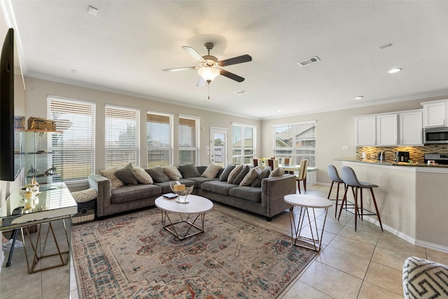 20511 Noble Ranch Ct, Richmond, TX 77407 - living area with light tile patterned flooring, plenty of natural light, a ceiling fan, crown molding, and baseboards