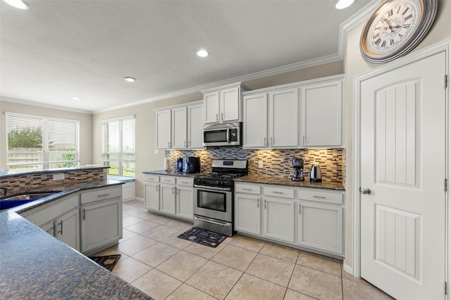 20511 Noble Ranch Ct, Richmond, TX 77407 - kitchen with appliances with stainless steel finishes, tasteful backsplash, crown molding, a sink, and light tile patterned floors