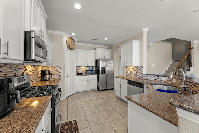 20511 Noble Ranch Ct, Richmond, TX 77407 - kitchen featuring appliances with stainless steel finishes, a sink, decorative backsplash, dark stone countertops, and ornamental molding