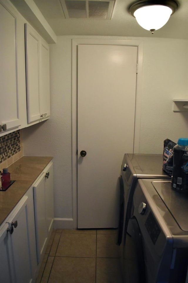 12605 Wellington Park Dr Unit 17, Houston, TX 77072 - laundry area with washing machine and clothes dryer, cabinet space, light tile patterned flooring, and baseboards
