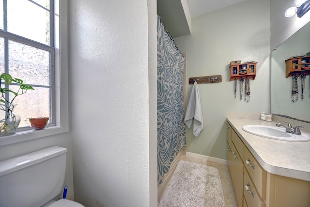 213 N Austin St, Brenham, TX 77833 - bathroom featuring vanity, toilet, tile patterned floors, curtained shower, and baseboards