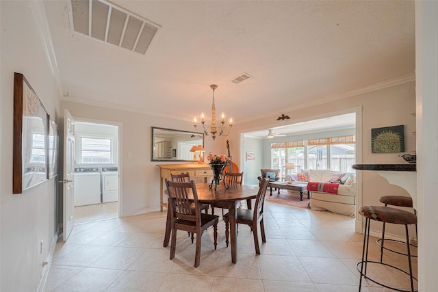 10318 Raritan Dr, Houston, TX 77043 - dining room with washer and clothes dryer, crown molding, plenty of natural light, a chandelier, and light tile patterned flooring