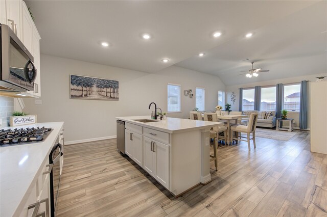 2432 Solaris Bend Dr, Katy, TX 77493 - kitchen featuring a sink, stainless steel appliances, light wood finished floors, plenty of natural light, and vaulted ceiling