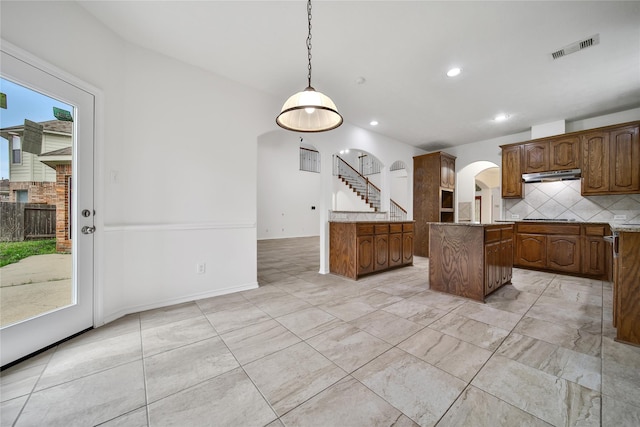 714 Stubbs Bend Dr, Rosenberg, TX 77469 - kitchen featuring arched walkways, under cabinet range hood, plenty of natural light, tasteful backsplash, and recessed lighting