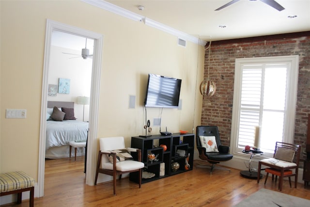 2207 Post Office St, Galveston, TX 77550 - sitting room featuring ceiling fan, wood finished floors, healthy amount of natural light, brick wall, and ornamental molding