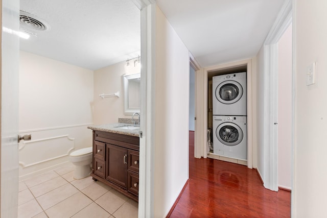 12633 Memorial Dr Unit 170, Houston, TX 77024 - laundry room featuring stacked washing machine and dryer and light wood-type flooring