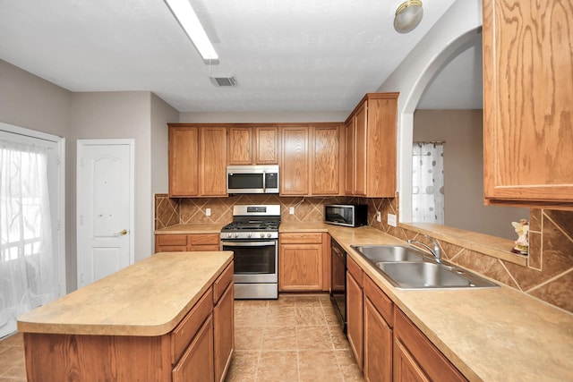 2202 Donrel Way, Houston, TX 77067 - kitchen featuring black appliances, a sink, tasteful backsplash, light countertops, and arched walkways