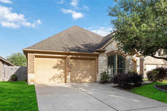 10910 Brighton Gardens Dr, Richmond, TX 77406 - view of front of home featuring stone siding, concrete driveway, a garage, a shingled roof, and brick siding