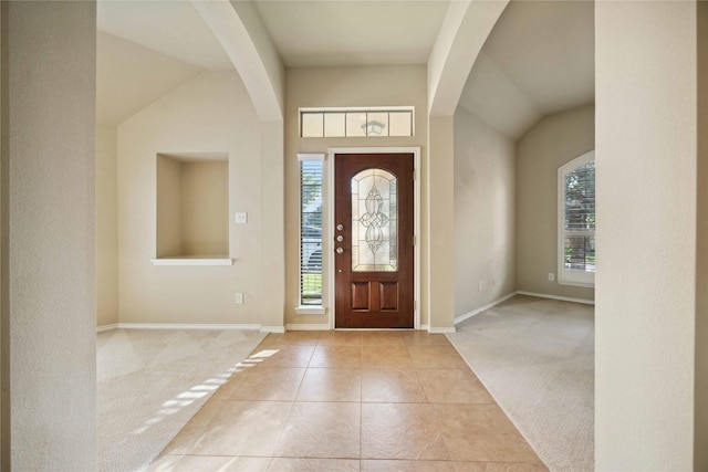 10910 Brighton Gardens Dr, Richmond, TX 77406 - foyer entrance featuring light carpet, arched walkways, baseboards, light tile patterned floors, and lofted ceiling