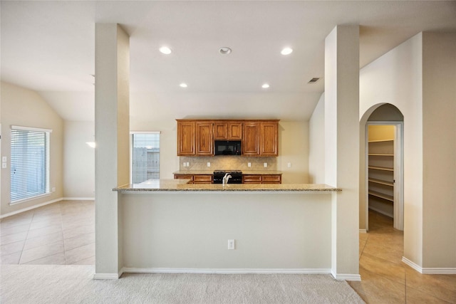 10910 Brighton Gardens Dr, Richmond, TX 77406 - kitchen with black microwave, light tile patterned flooring, arched walkways, decorative backsplash, and recessed lighting