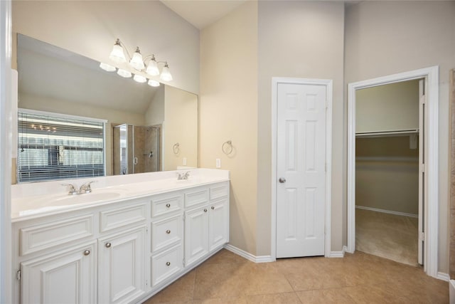 10910 Brighton Gardens Dr, Richmond, TX 77406 - full bathroom featuring double vanity, a stall shower, tile patterned floors, baseboards, and a walk in closet