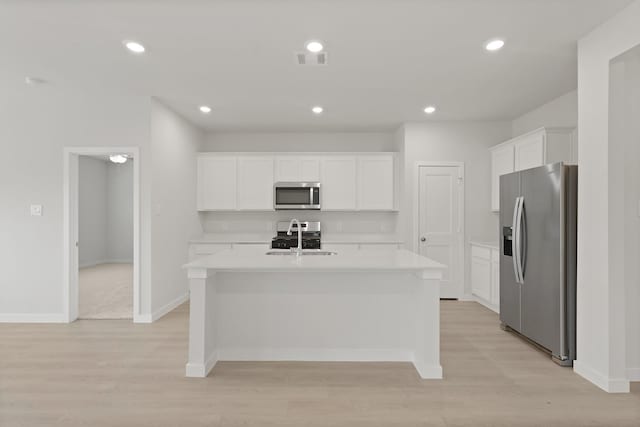 21406 George Wayne Way, Spring, TX 77379 - kitchen with stainless steel appliances, light countertops, white cabinets, light wood-style floors, and recessed lighting