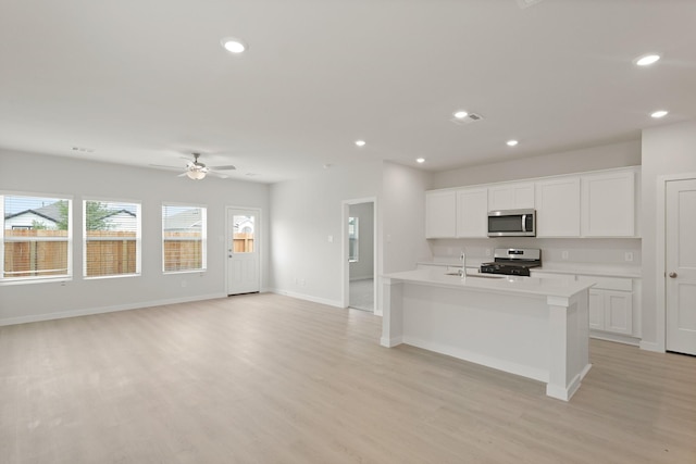 21406 George Wayne Way, Spring, TX 77379 - kitchen with appliances with stainless steel finishes, light wood finished floors, recessed lighting, light countertops, and a ceiling fan
