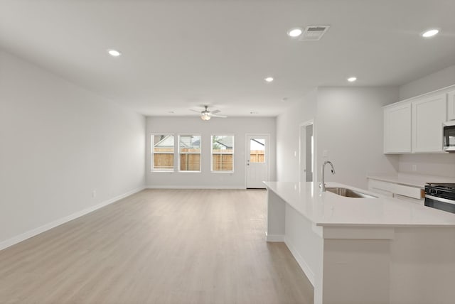 21406 George Wayne Way, Spring, TX 77379 - kitchen with a sink, open floor plan, stainless steel microwave, a ceiling fan, and recessed lighting