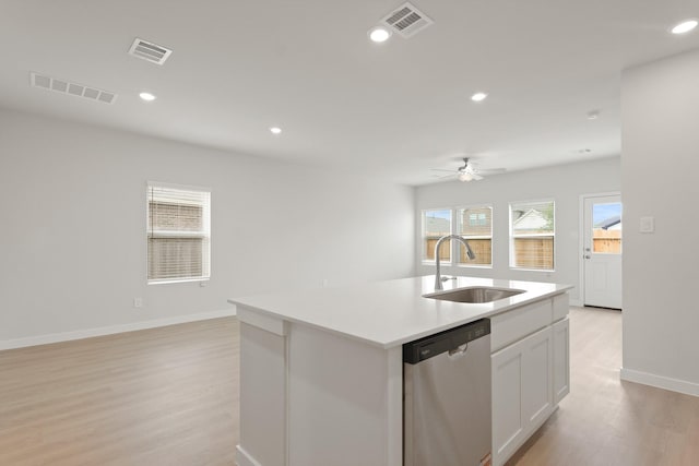 21406 George Wayne Way, Spring, TX 77379 - kitchen with stainless steel dishwasher, a sink, light wood-style flooring, a ceiling fan, and an island with sink
