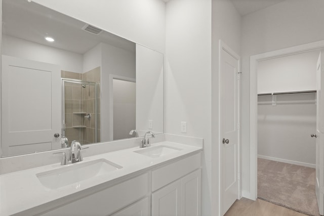 21406 George Wayne Way, Spring, TX 77379 - full bath with a shower stall, double vanity, a spacious closet, wood finished floors, and baseboards