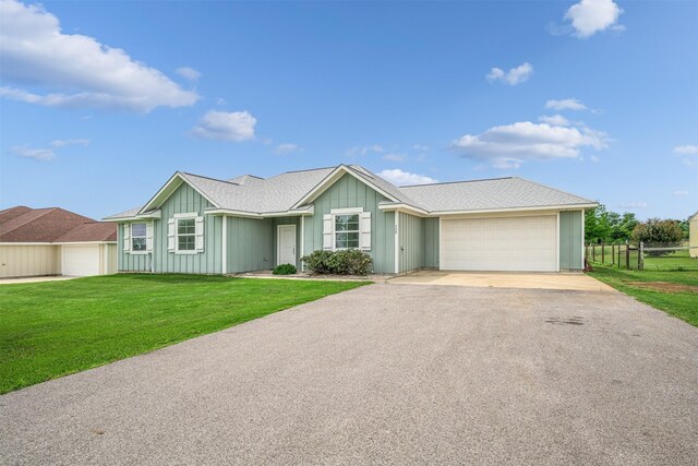 305-335 Omalley Rd, Brenham, TX 77833 - single story home featuring asphalt driveway, a garage, and board and batten siding