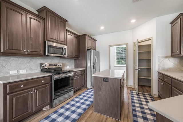 305-335 Omalley Rd, Brenham, TX 77833 - kitchen featuring stainless steel appliances, a center island, light wood-style floors, dark brown cabinetry, and light countertops