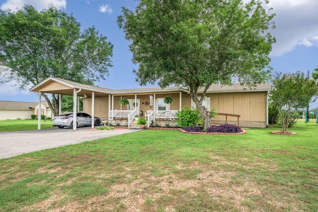 305-335 Omalley Rd, Brenham, TX 77833 - view of front facade featuring covered porch, a carport, a front yard, and asphalt driveway