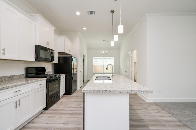 6822 Tuskegee St, Houston, TX 77091 - kitchen with black appliances, a sink, white cabinets, crown molding, and an island with sink