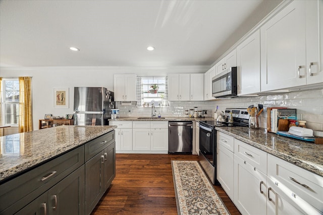 1101 E 38th St, Houston, TX 77022 - kitchen featuring stainless steel appliances, a sink, white cabinets, backsplash, and light stone counters