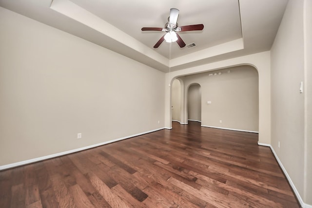 13906 Mowbray Ct, Richmond, TX 77407 - empty room featuring arched walkways, a tray ceiling, ceiling fan, wood finished floors, and baseboards