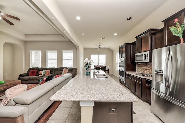 13906 Mowbray Ct, Richmond, TX 77407 - kitchen with stainless steel appliances, a ceiling fan, open floor plan, a sink, and decorative backsplash