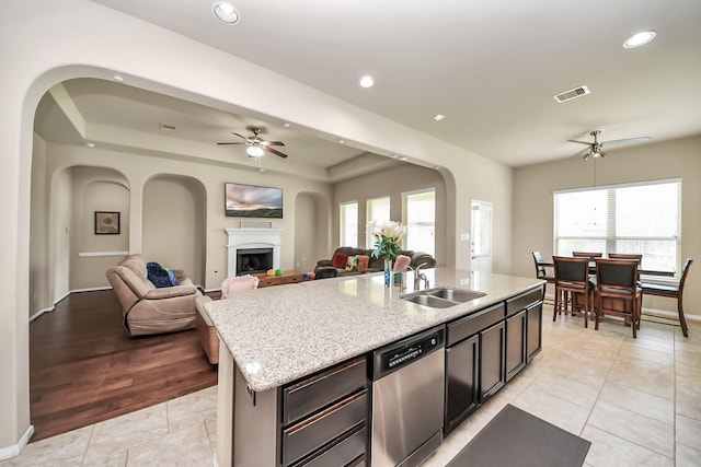 13906 Mowbray Ct, Richmond, TX 77407 - kitchen featuring dishwasher, a ceiling fan, open floor plan, a sink, and a fireplace