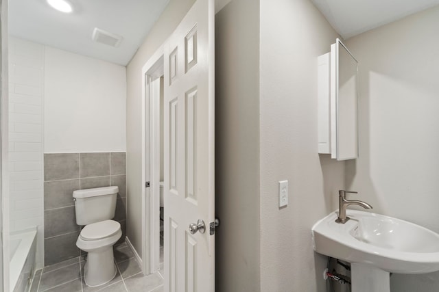 1405 Shadowdale Dr Unit 73, Houston, TX 77043 - bathroom with toilet, tile patterned flooring, tile walls, and a sink