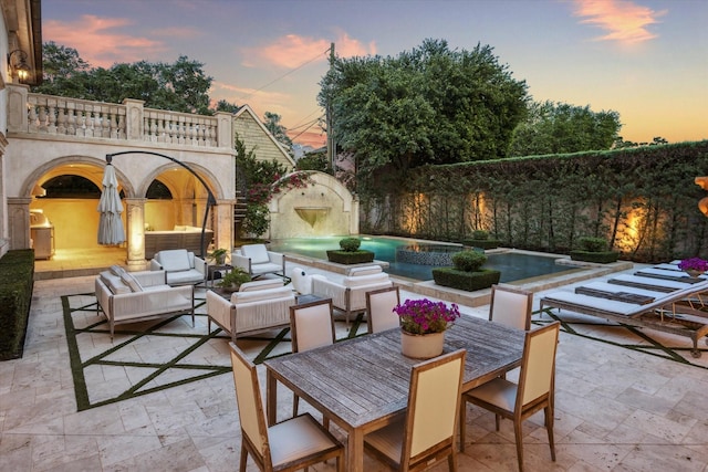 2307 River Oaks Blvd, Houston, TX 77019 - patio terrace at dusk with a patio area, an outdoor living space, a pool with connected hot tub, and outdoor dining space