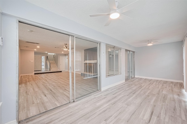 2115 Streamcrest Ln, Sugar Land, TX 77479 - unfurnished room with ceiling fan, stairs, wood finished floors, a textured ceiling, and baseboards