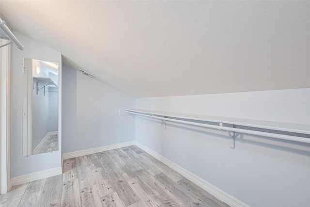 2115 Streamcrest Ln, Sugar Land, TX 77479 - walk in closet with vaulted ceiling and light wood-style floors