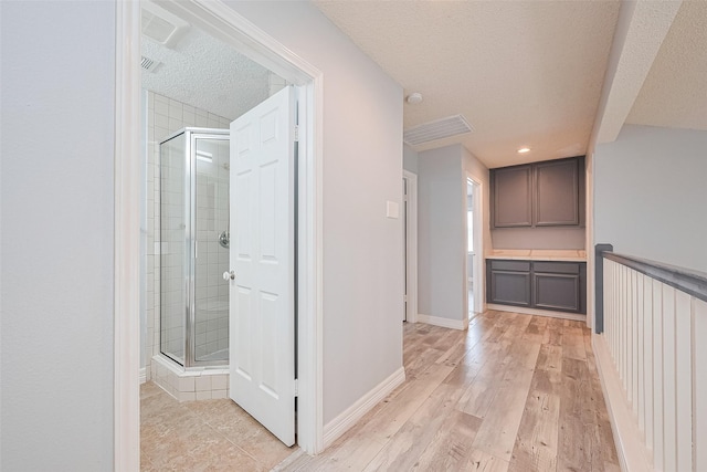 2115 Streamcrest Ln, Sugar Land, TX 77479 - hall featuring a textured ceiling, light wood-style floors, and baseboards