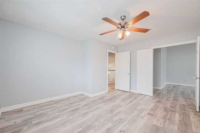 2115 Streamcrest Ln, Sugar Land, TX 77479 - unfurnished bedroom with light wood-style flooring, a textured ceiling, baseboards, and ceiling fan
